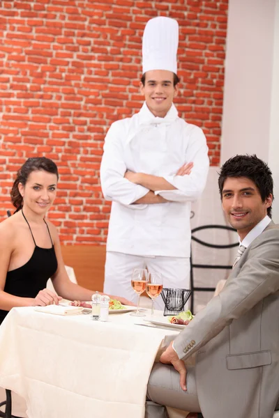 Chef stood with couple in restaurant Royalty Free Stock Images