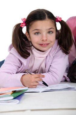 Young girl doing her homework clipart