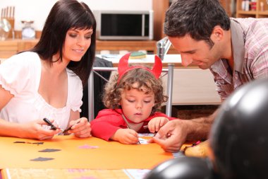 Little boy dressed ad devil with his parents clipart