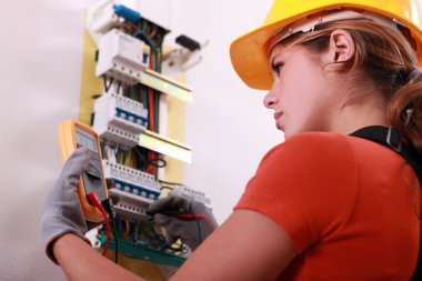 Woman measuring electrical current clipart
