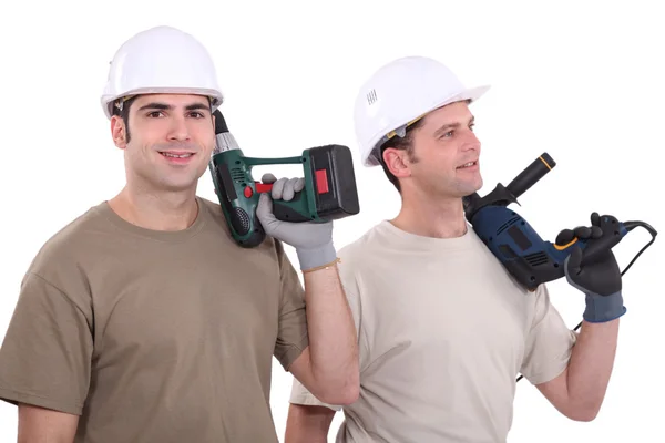 Zwei männliche Bauarbeiter mit Bohrmaschine — Stockfoto