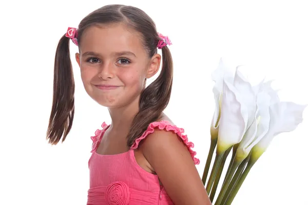 En liten flicka som bär liljor. — Stockfoto