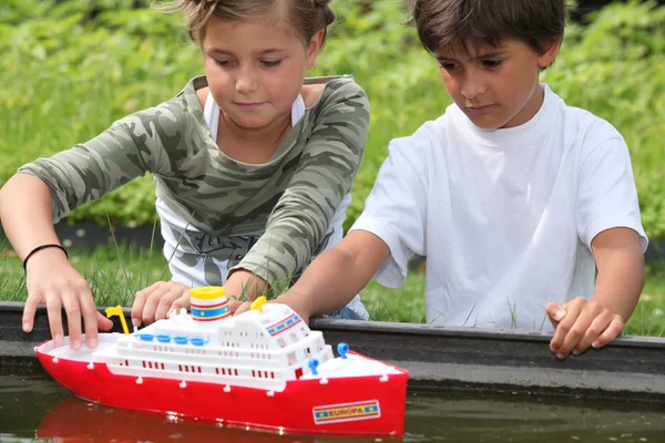 Children playing with boat — Stock Photo, Image