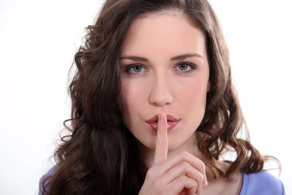 Woman with finger over mouth — Stock Photo, Image