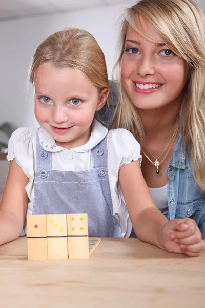 Woman and child playing dominoes — Stock Photo, Image