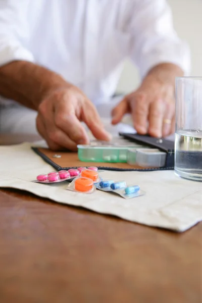 Alte Dame nutzt Pillbox, um Medikamente zu organisieren — Stockfoto