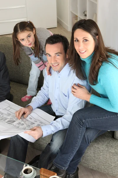 Family watching architectural blueprint — Stock Photo, Image