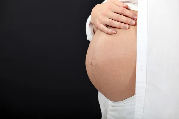 Žena hladí její těhotné břicho — Stock fotografie