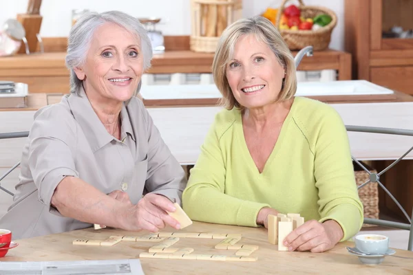 Duo de senhoras aposentadas jogando scrabble na cozinha — Fotografia de Stock