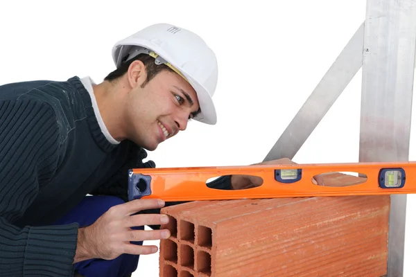 Bricklayer with a spirit level — Stockfoto