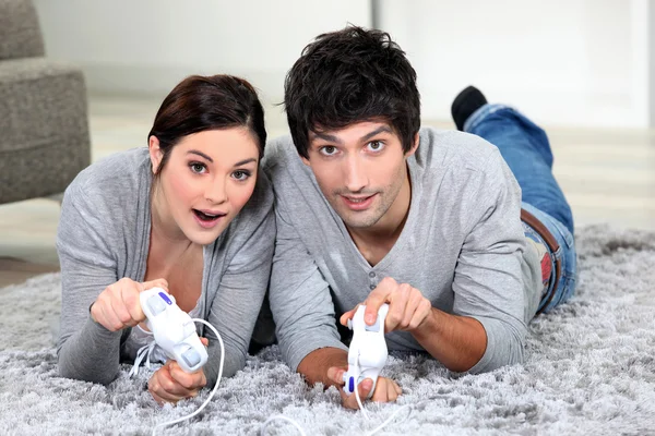 Par på matta spelar TV-spel — Stockfoto