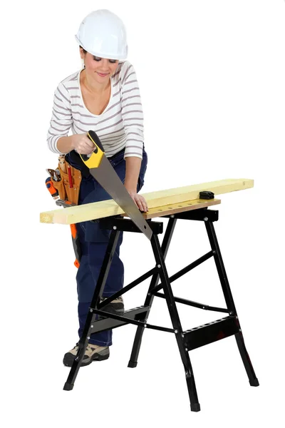 Mulher serrar madeira no banco de trabalho — Fotografia de Stock