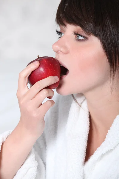 Kobieta gryzący w pyszne czerwone jabłko — Zdjęcie stockowe