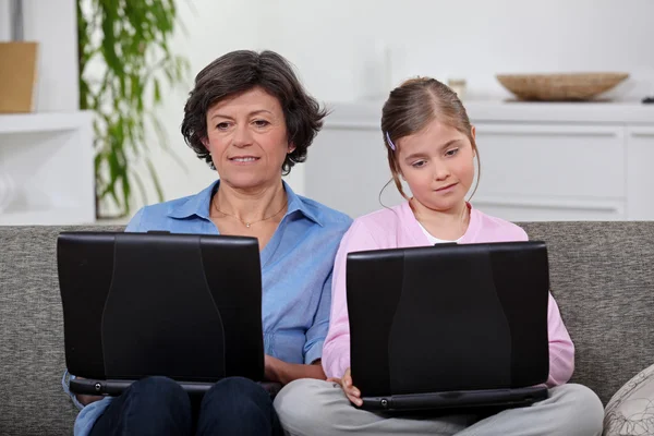Mère et fille chacune avec leur propre ordinateur portable — Photo