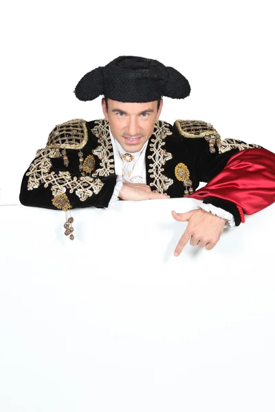 Άνθρωπος σε ένα κοστούμι matador με έναν πίνακα που είναι κενό για κείμενο ή εικόνα — Φωτογραφία Αρχείου