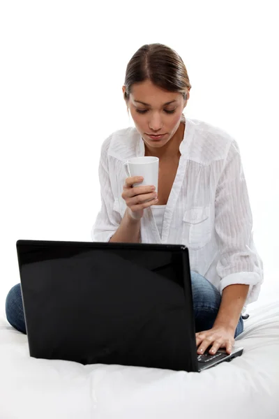 Женщина с компьютером и кофе — стоковое фото