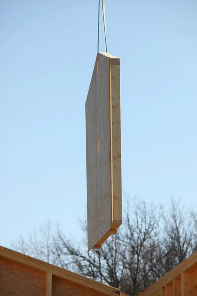 Grúa levantando una pared de madera en su lugar — Foto de Stock