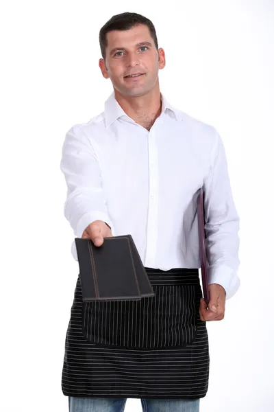 Waiter holding out two menus — Stock Photo, Image