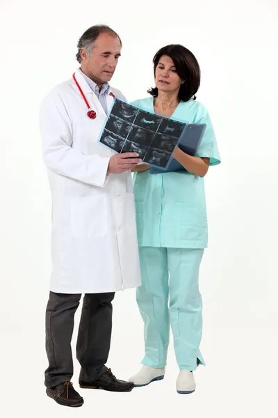 Γιατρός και νοσοκόμα κοιτάζοντας ακτίνες Χ — Φωτογραφία Αρχείου