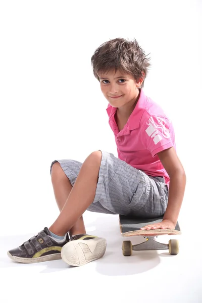 Kind sitzt auf seinem Skateboard — Stockfoto
