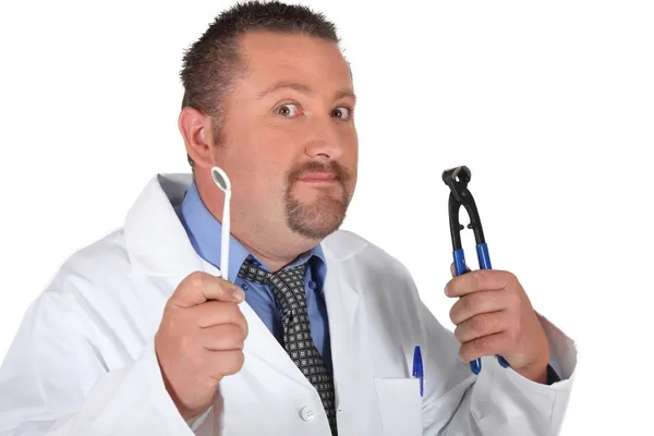 Dentist holding a mirror and a pair of pliers — Stock Photo, Image