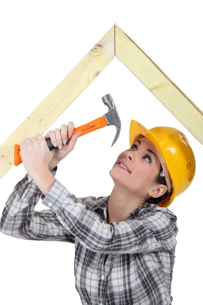 Tradeswoman hammering a frame — Stock Photo, Image