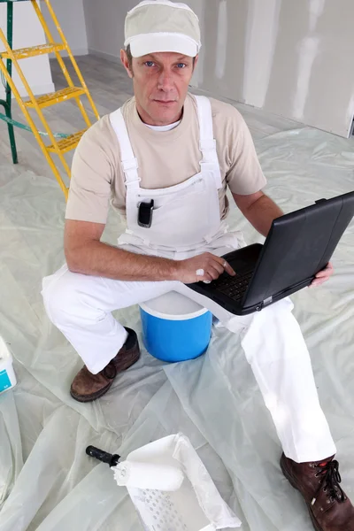 Painter taking a break from work to check e-mails — Stock Photo, Image