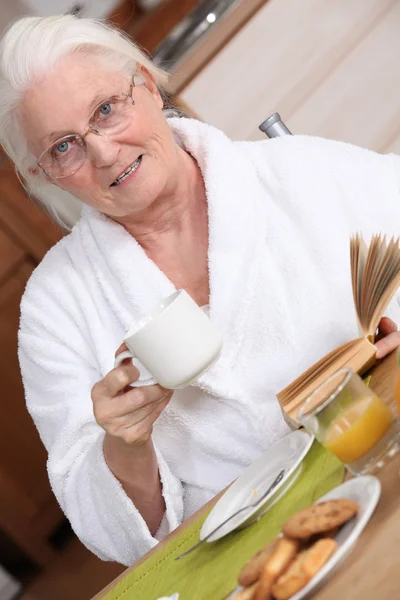 Ältere Frau frühstückt — Stockfoto