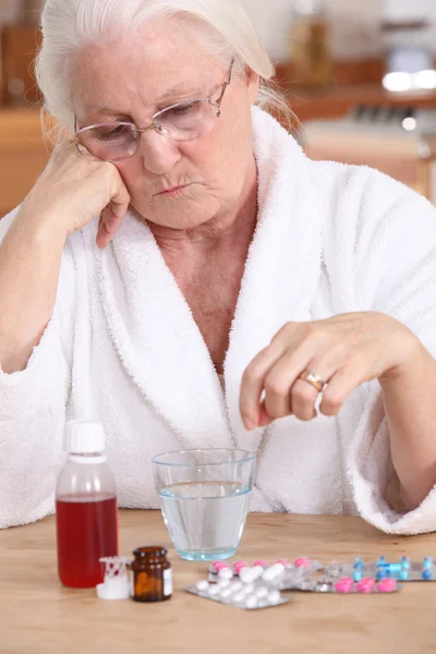 Oudere dame zat met haar medicatie — Stockfoto