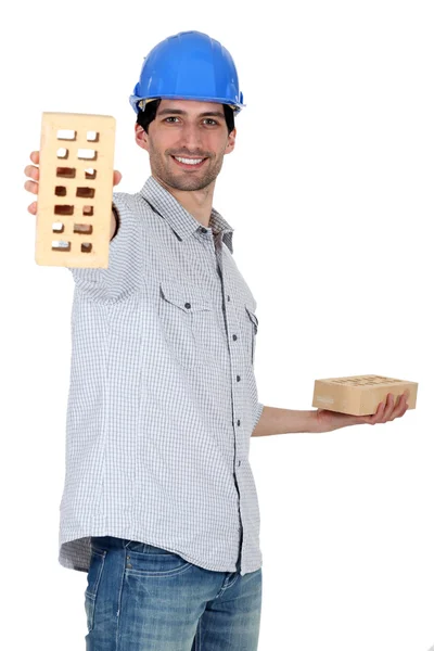 Builder holding an engineering brick — Stockfoto