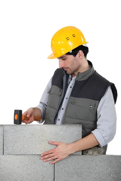 Mason met behulp van hamer te kloppen bouwstenen in plaats — Stockfoto