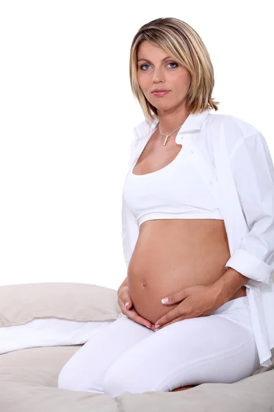 Mujer embarazada posando en la cama —  Fotos de Stock