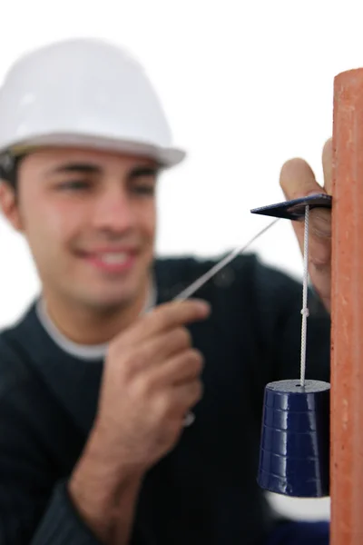 Mason usando pêndulo para verificar a parede — Fotografia de Stock