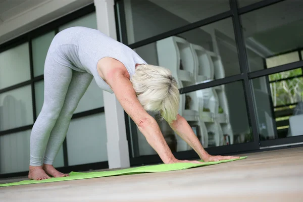 Femme âgée pratiquant le yoga — Photo