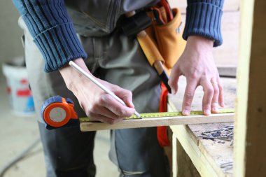 Joiner marking off plank of wood clipart