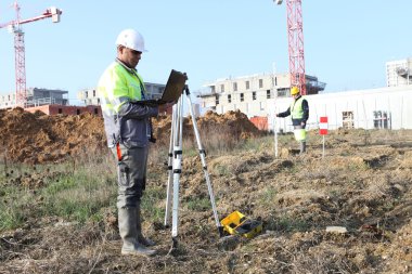 Surveyor on site with a laptop clipart