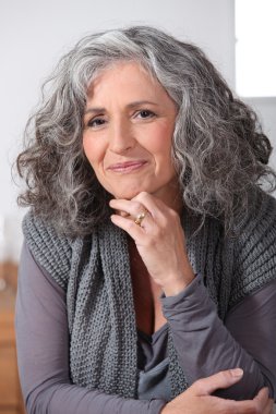 Grey-haired woman touching chin clipart