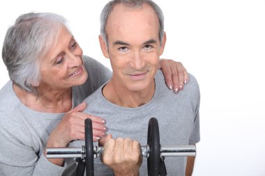 Woman admiring a man lifting a dumbell clipart