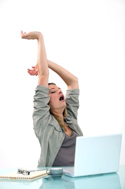 Woman yawning at desk clipart