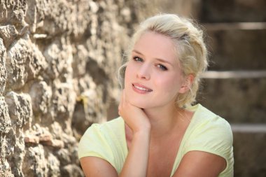 Blonde woman next to stone wall clipart