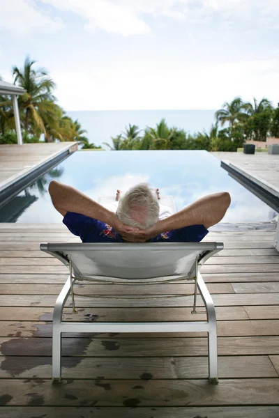 Senior man relaxing poolside — Stock Photo, Image