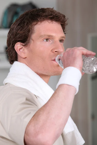 Άνθρωπος πόσιμο νερό μετά από συνεδρία γυμναστήριο — Φωτογραφία Αρχείου