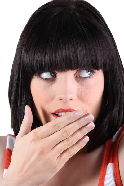 Γυναίκα με ένα βαρίδι κρατώντας το χέρι της πάνω από το στόμα — Φωτογραφία Αρχείου