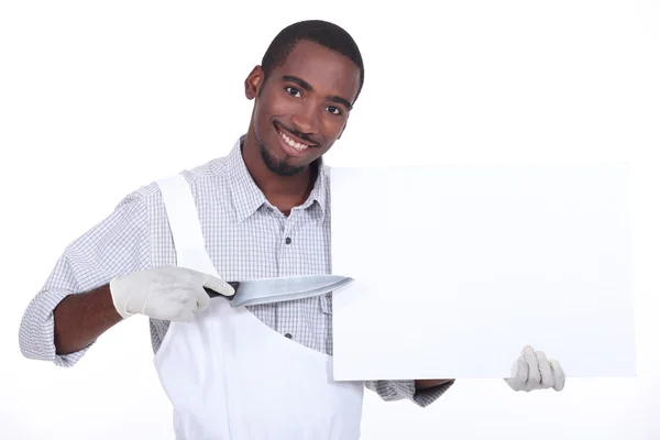Hombre apuntando un cuchillo a un tablero dejado en blanco para su mensaje — Foto de Stock
