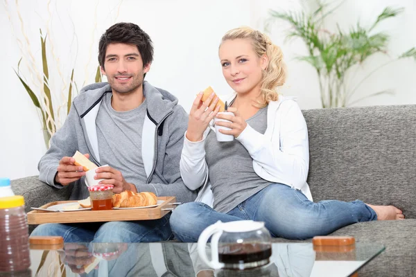 Paar frühstückt auf Couch — Stockfoto
