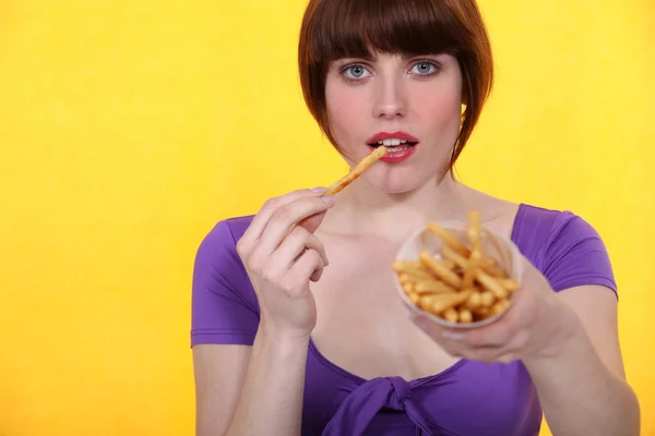 Брюнетка ест конус чипсов — стоковое фото