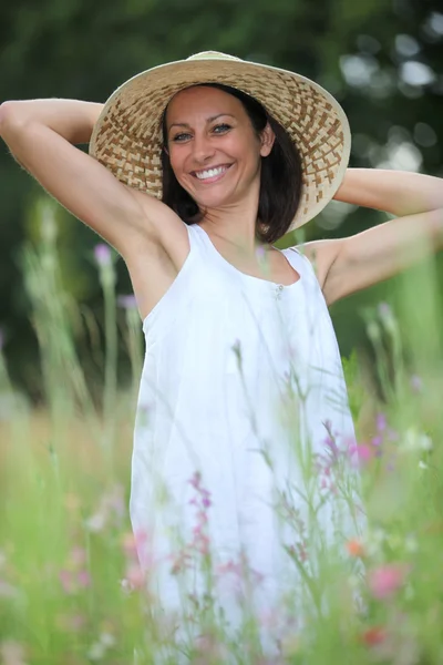 Woman with hat in the field — Stock Photo, Image