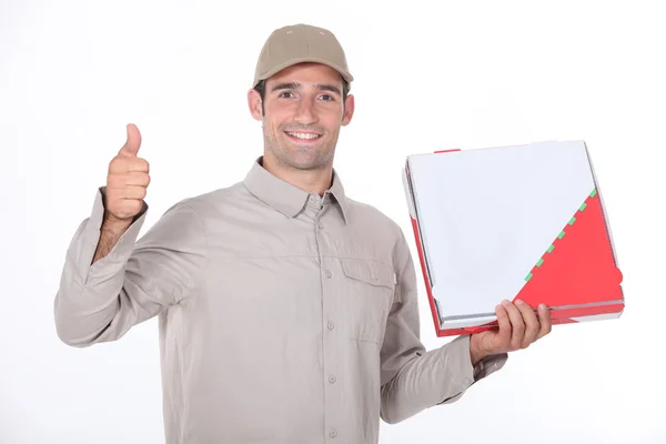 En leverans man håller ett paket och gör tummen upp — Stockfoto