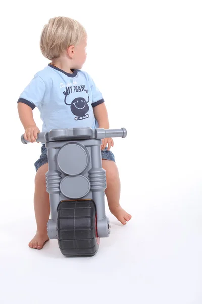Criança em uma moto de brinquedo — Fotografia de Stock