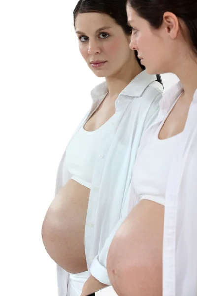 Беременная женщина смотрит в зеркало — стоковое фото